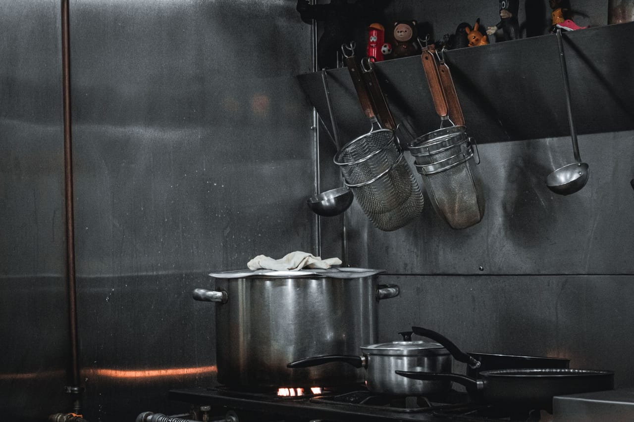 Cozinha profissional com bancadas e equipamentos em aço inoxidável