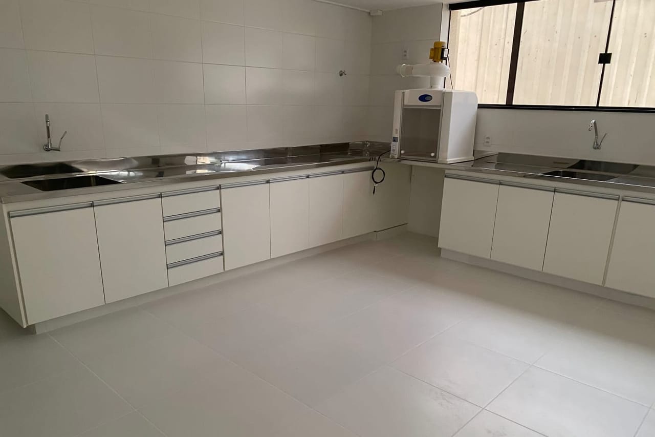 Copa com bancada e armários em aço inox instalados em ambiente acabado